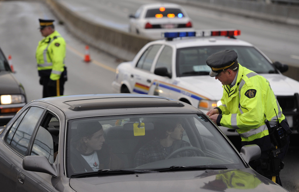An RCMP officer stops a car as part of the CounterAttack program in B.C. PNG Files, Driving 
