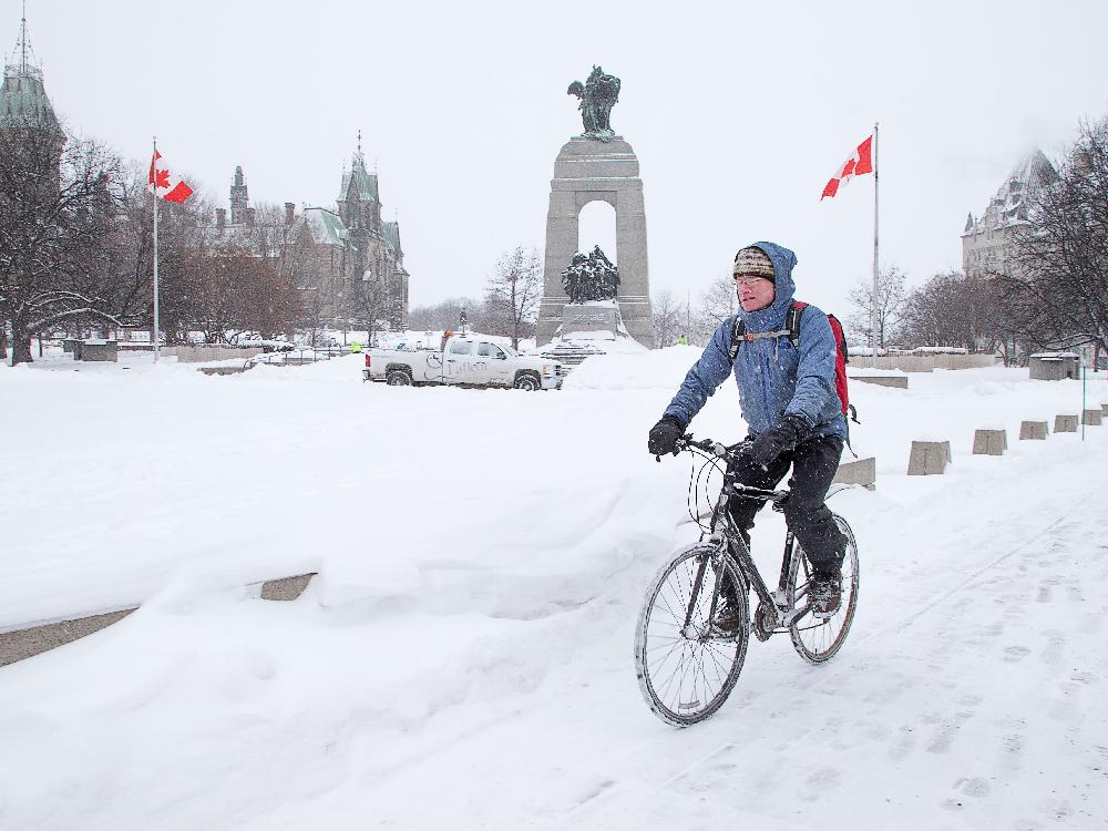  A cyclist makes his way past the National War Memorial as the region experiences a snowy day. Wayne Cuddington / Ottawa Citizen 