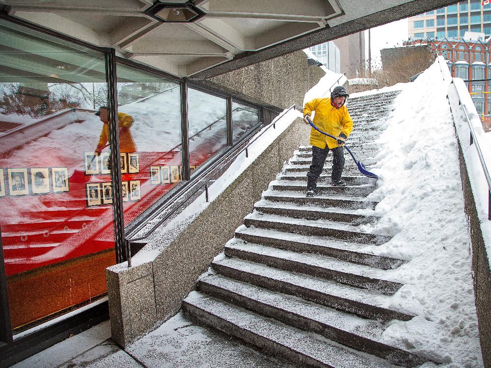  Sahbi Aessa clears snow from the steps of the NAC as the region experiences a snowy day Wayne Cuddington / Ottawa Citizen