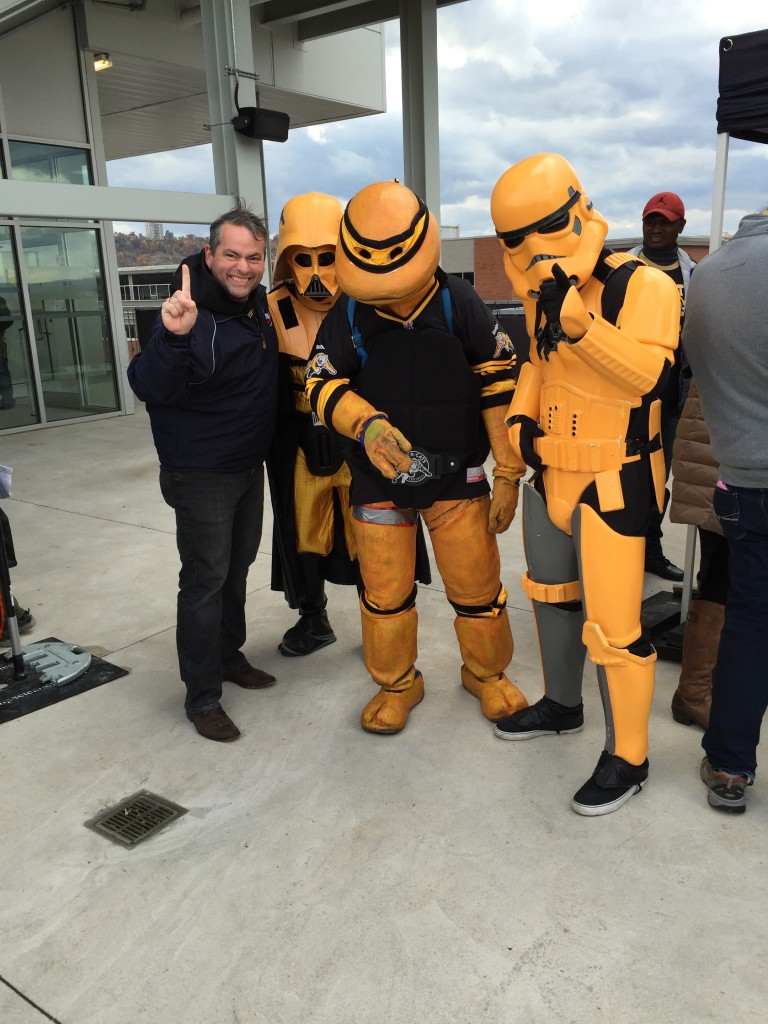 XPolice President stands next to costumed Ticats fans.