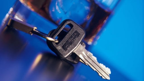 keys in the foreground with an alcohol beverage blurred in the background