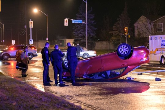Halton police stand next to the rolled-over vehicle