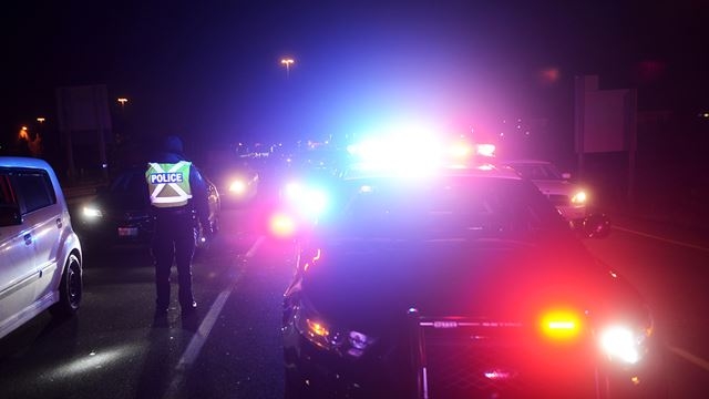 A police officer stopped with lights on at night in Durham.