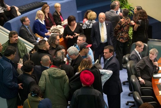 Todd Korol/Toronto Star Security guards hold back taxi cab drivers while they disrupted a city council meeting.