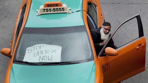 A taxi driver protests Uber in Toronto on June 1, 2015. Hamilton city councillors voted Wednesday to outlaw any Uber drivers who don't have proper commercial insurance, although city officials admit there's no real way to stop them. (Nathan Denette/The Canadian Press)