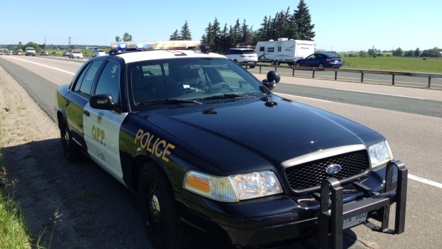 An OPP cruiser with its lights on, stopeed at the side of the road.