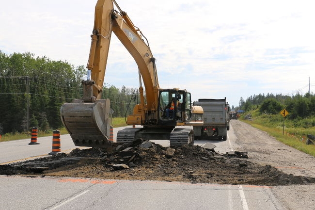 An excavator digs up a portion of Highway 101.
