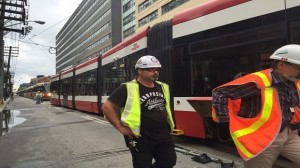 Repair crew standing next to the derailed streetcar.