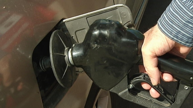 A closeup of a man filling a vehicle at a gas station.
